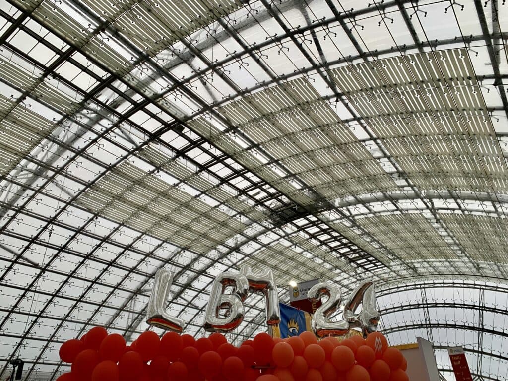 Glashalle der Leipziger Buchmesse mit einer schwebenden Buchstabeninstallation